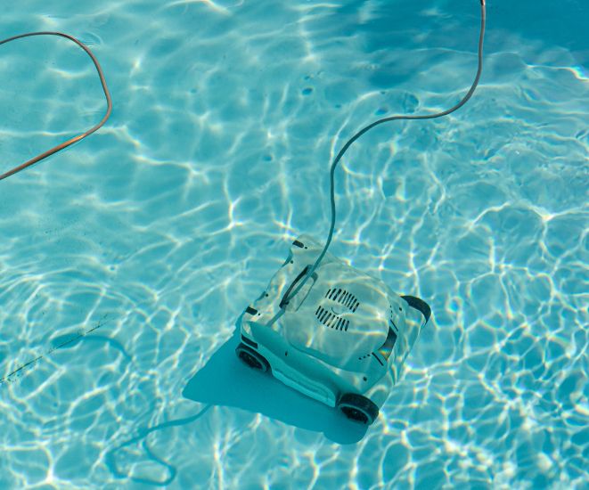 A robotic pool cleaner at the bottom of a pool.