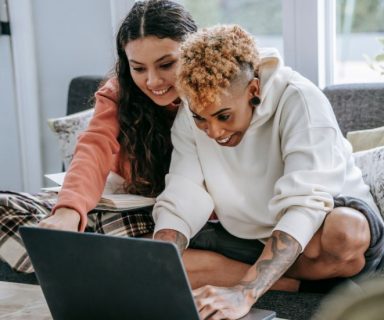 Two people using a laptop together.