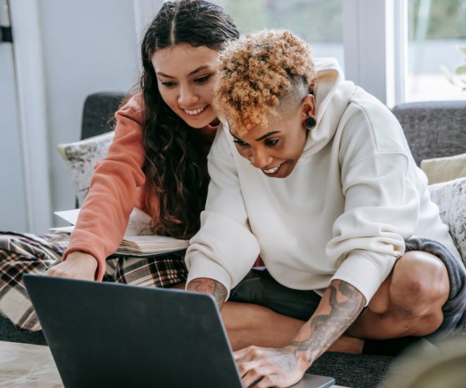 Two people using a laptop together.