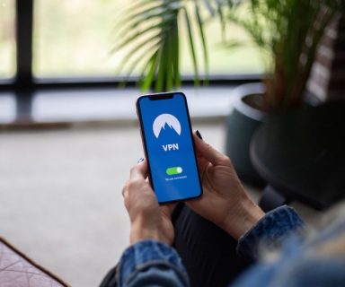 A person holding a cell phone displaying a VPN.