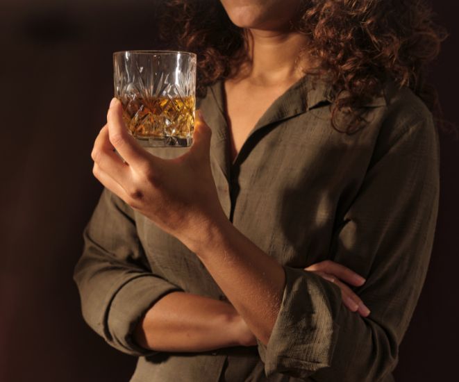 A woman holding a glass of whisky.