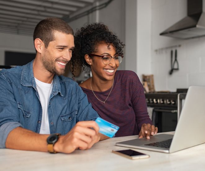 A couple looking at a laptop together.